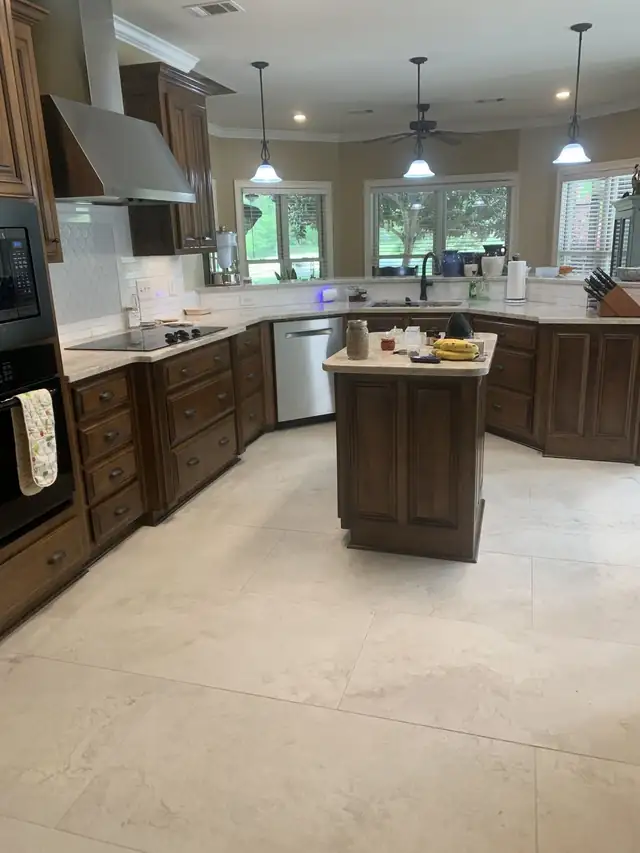 Kitchen with dark wood cabinets, a center island and light stone countertops