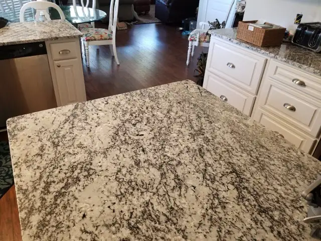 Close-up of a speckled white, grey and black granite island top cut from a full slab